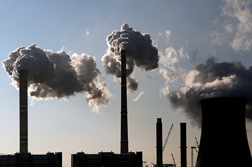 coal smoking power plant against the sun