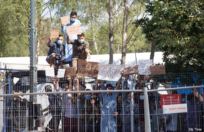 16 August 2021, Lithuania, Rudninkai: Migrants at the migrant camp in Rudninkai in Lithuania hold up placards with inscriptions such as "Help Afghanistan" and similar demands during a rally. (to dpa: "Refugees as a weapon" - Lithuania's border region with Belarus in turmoil) Photo: Alexander Welscher/dpa (Photo by Alexander Welscher/picture alliance via Getty Images)