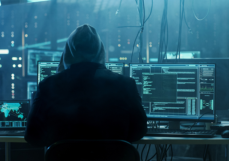 Dangerous Hooded Hacker Breaks into Government Data Servers and Infects Their System with a Virus. His Hideout Place has Dark Atmosphere, Multiple Displays, Cables Everywhere.