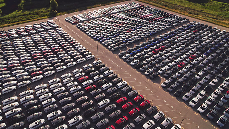 New hybrid EV cars stock parking. Aerial of parking lot of brand new cars for sale and transportation at manufacturer plant, automobile industry. Low carbon footprint electric vehicles from conveyor.